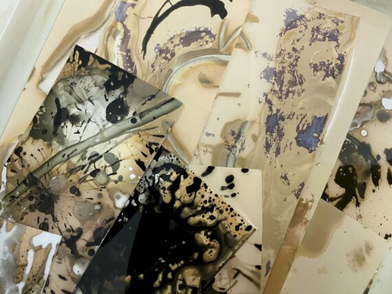 Die sich überlappenden Blätter zeigen abstrakte Motive in Beige-, Schwarz- und Violetttönen, die Spritzer, Wirbel und organische Muster aufweisen. (KI generierte Beschreibung)