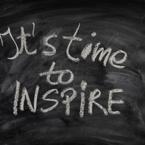 Der Satz "It's time to inspire" ist mit weißer Kreide auf eine schwarze Tafel geschrieben. (KI generierte Beschreibung)