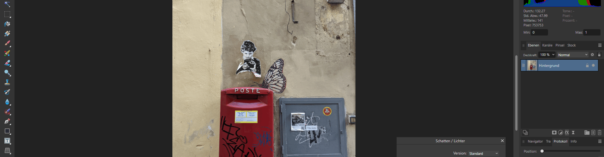 Ein roter Briefkasten mit Graffiti ist an einer beigen Wand angebracht, darunter eine schwarz-weiße Schablone mit einem Jungen und einem großen Schmetterlingsbild. Auch Stromkästen sind an der Wand angebracht. (KI generierte Beschreibung)